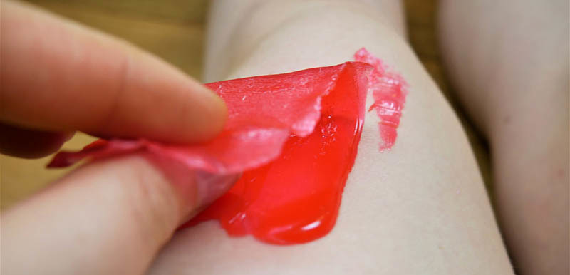 Pulling a wax strip from legs